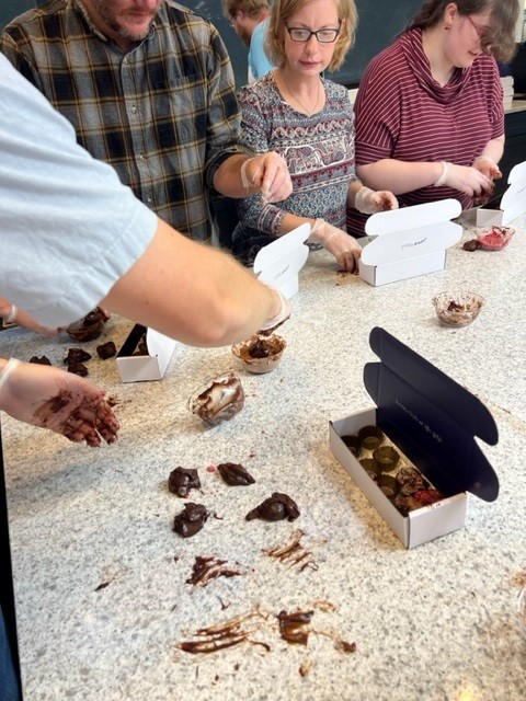 A group of people making chocolates