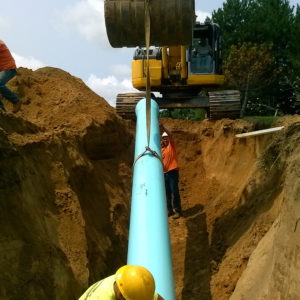 equipment and workers laying pipe