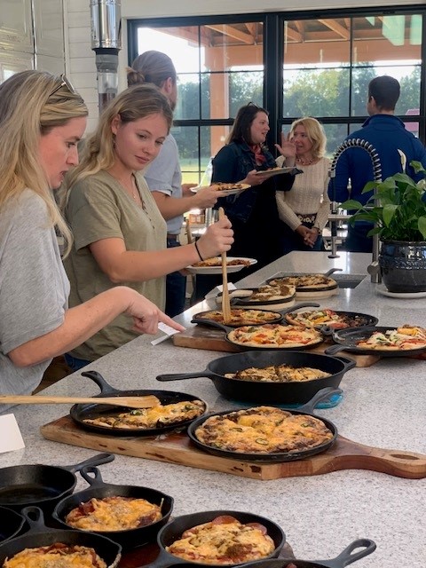 A group of people standing around a table with food