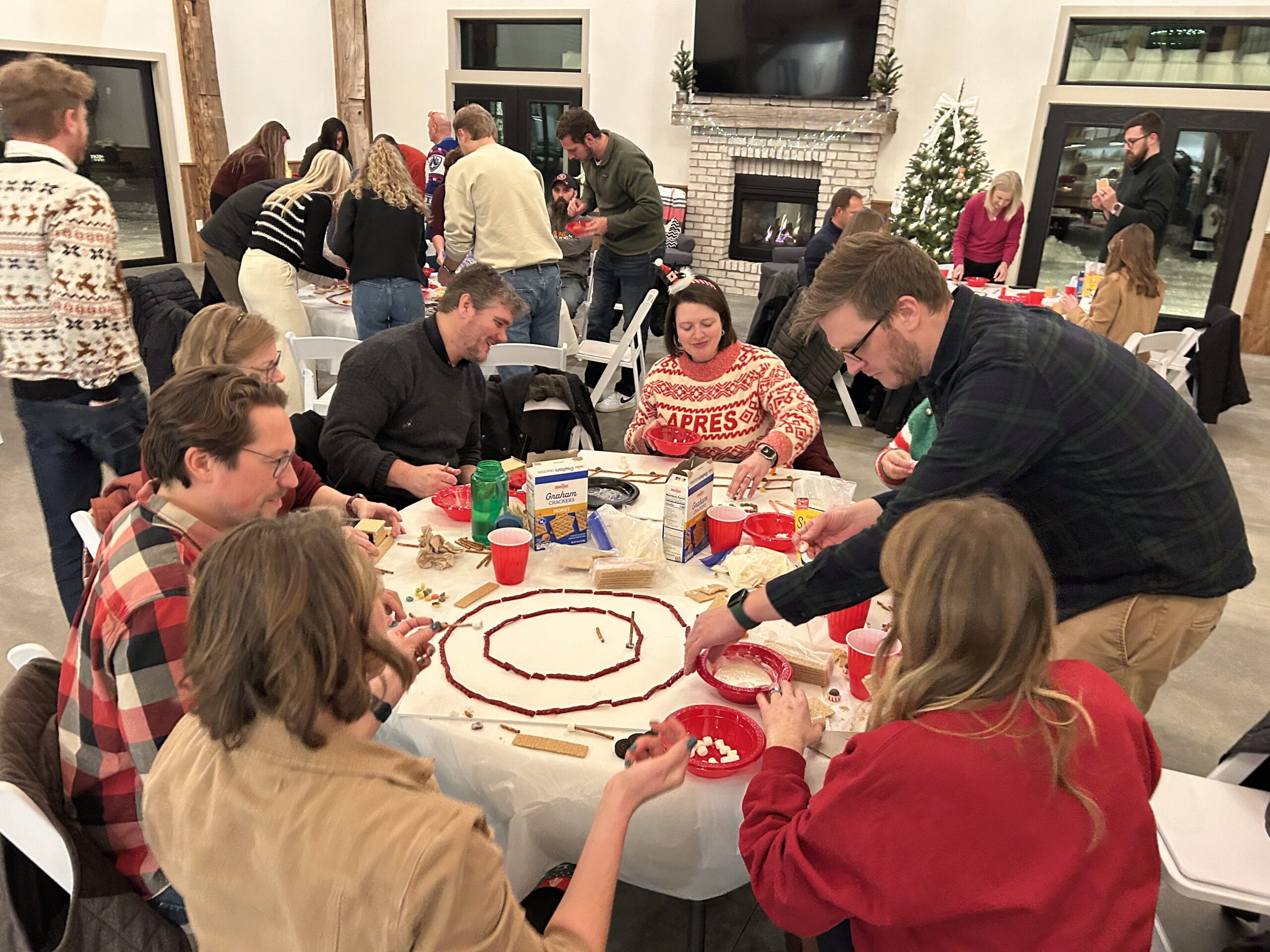 group of people building gingerbread creations