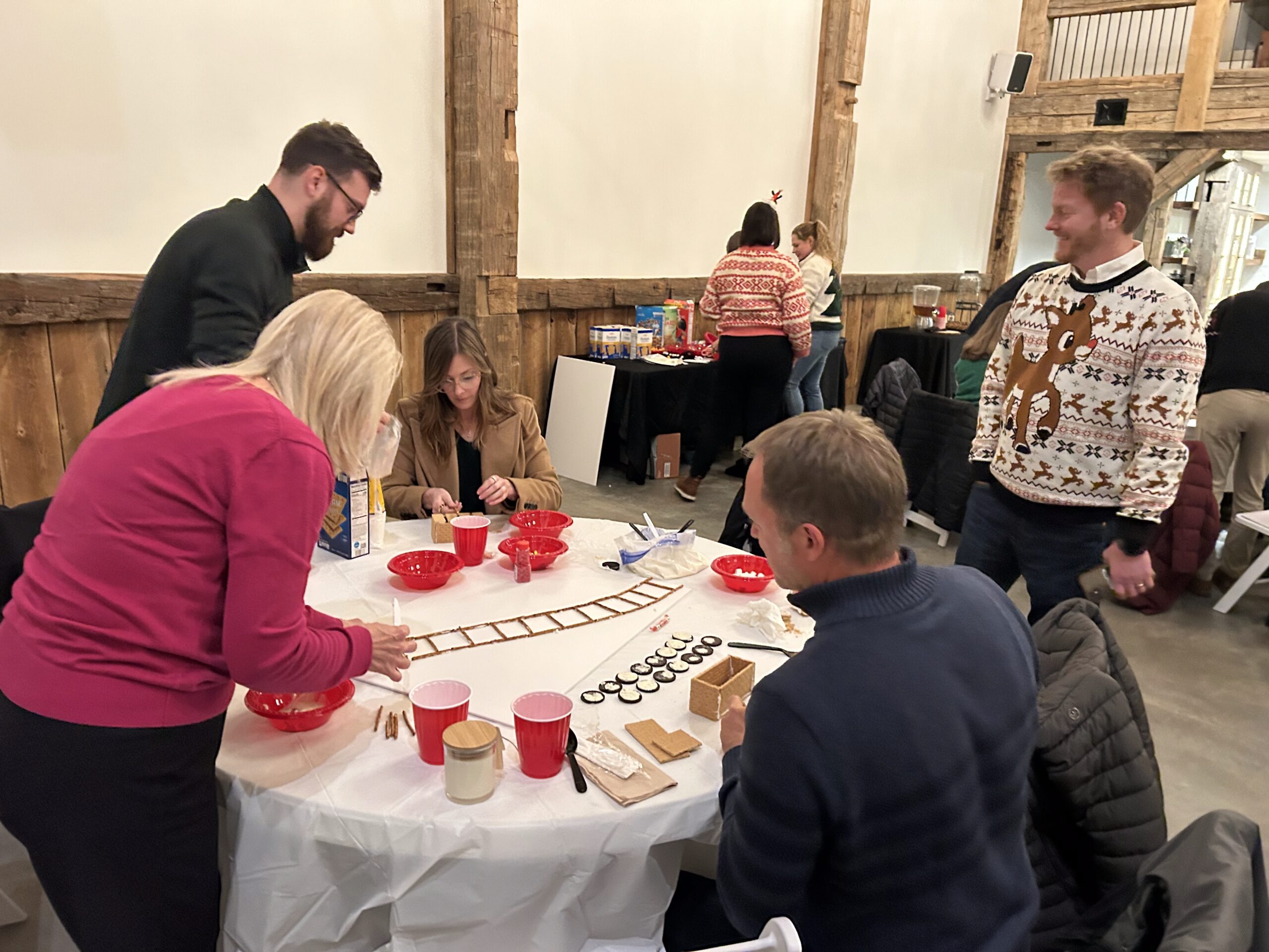 group of people building gingerbread creations