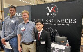 Nate and two students at a booth