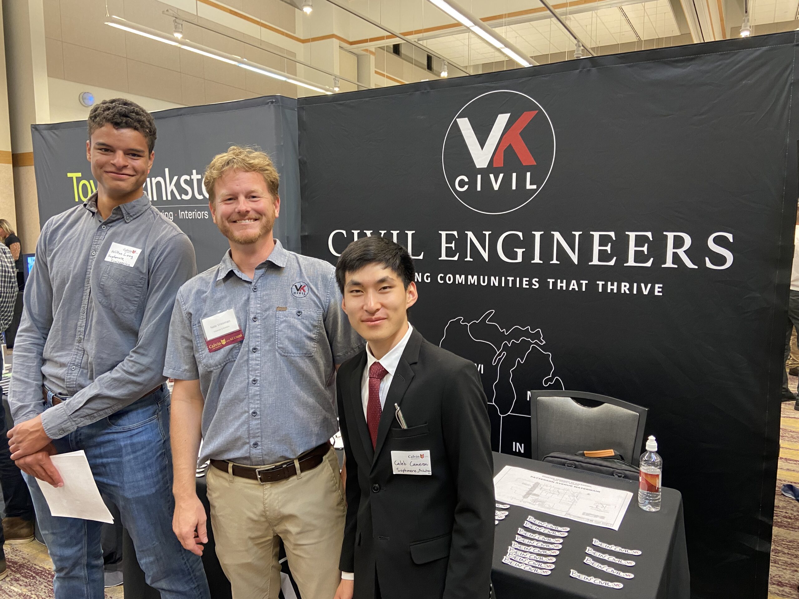 Nate and two students at a booth