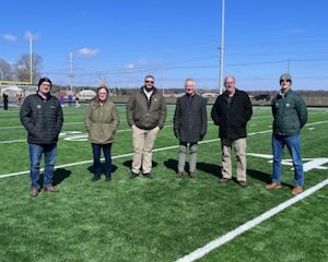 6 people standing on football field