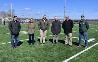6 people standing on football field